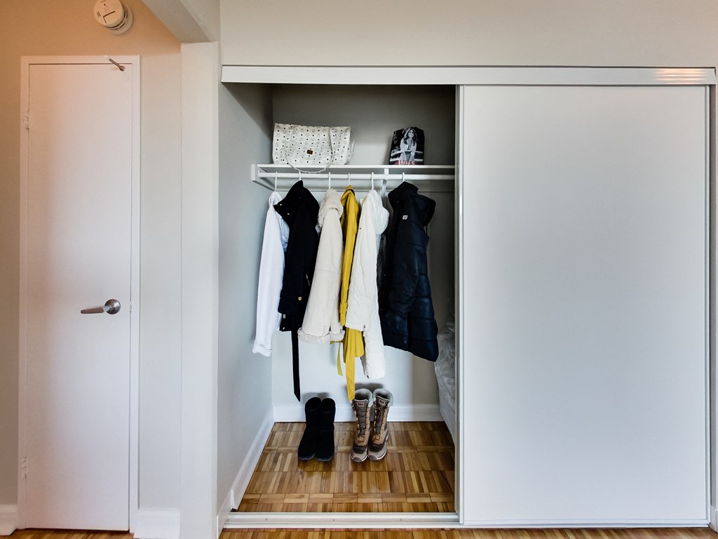 a small closet with clothes and shoes in it