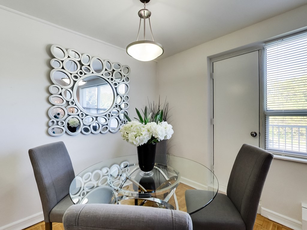 a dining room with a glass table and chairs