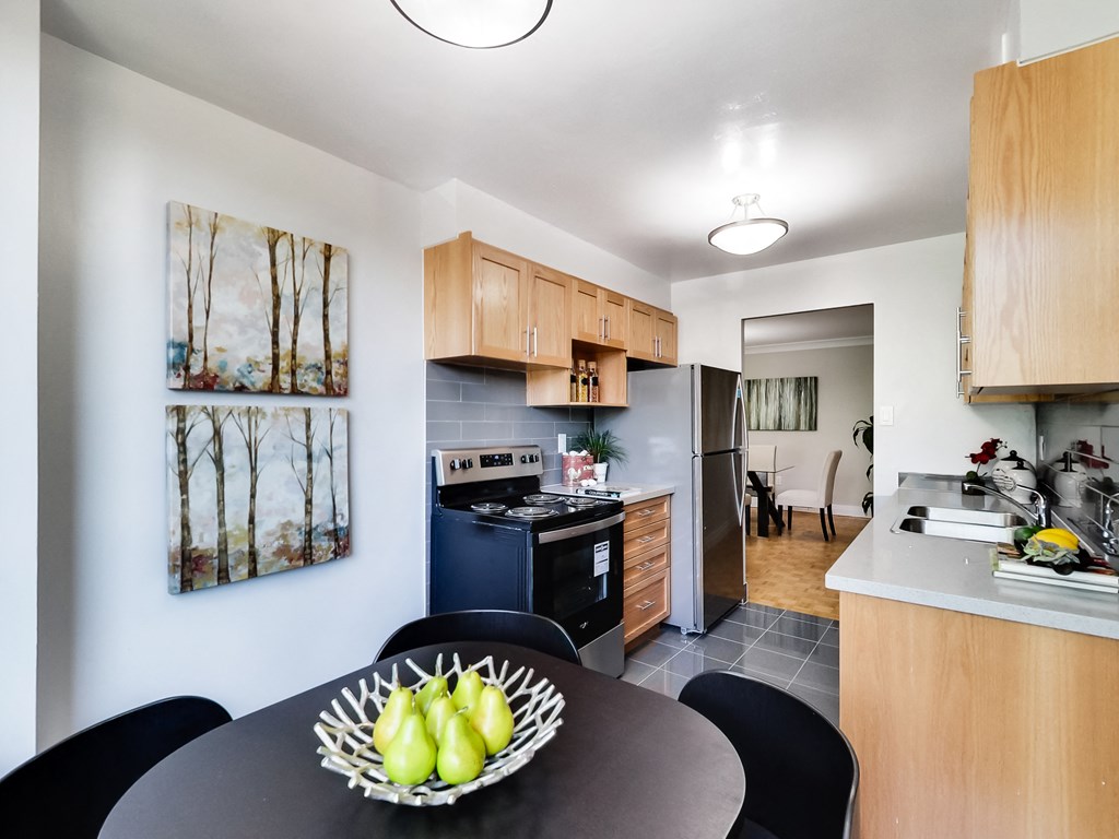 A kitchen with a table and chairs and a bowl of fruit on it.