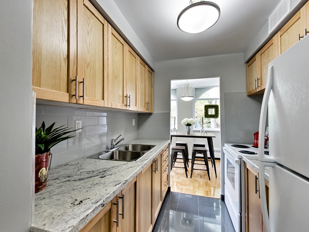A kitchen with wooden cabinets and a marble countertop.