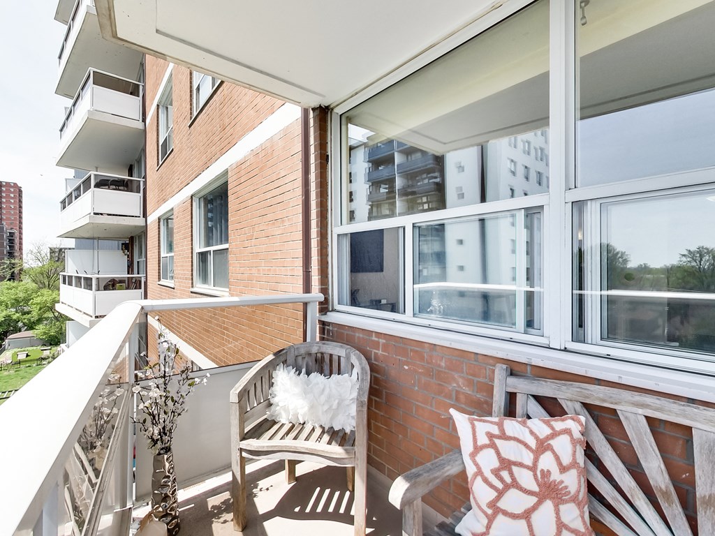 A balcony with a chair and a pillow.