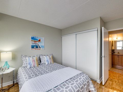 a bedroom with a bed and a mirrored wall