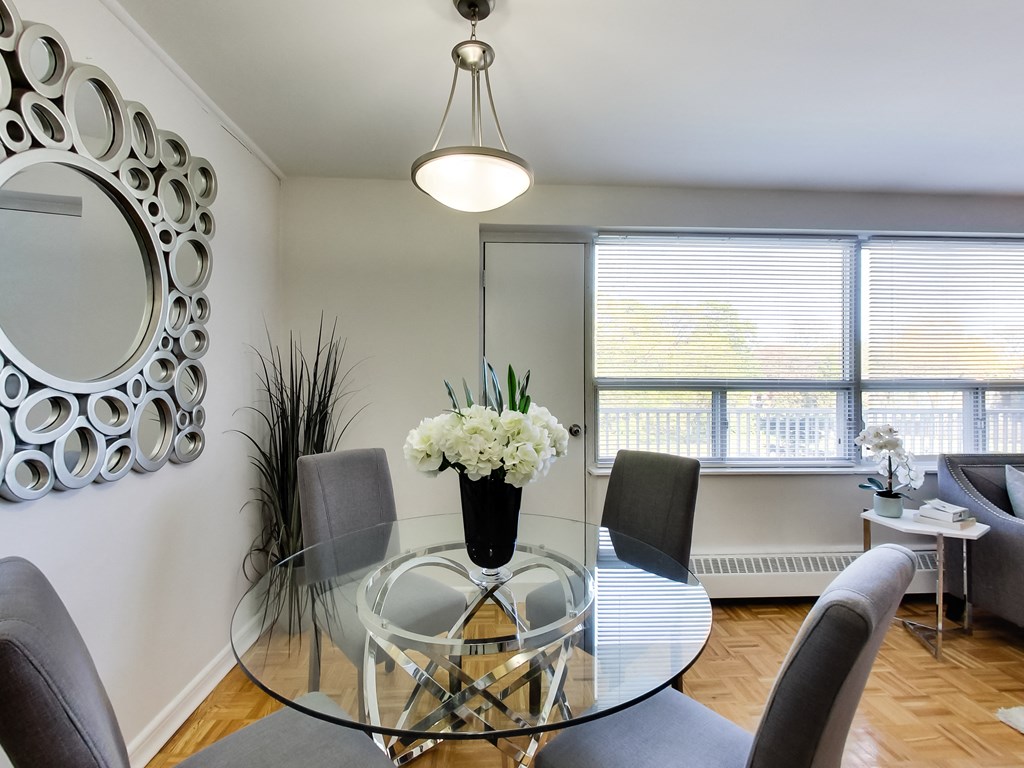 a dining room with a glass table and chairs