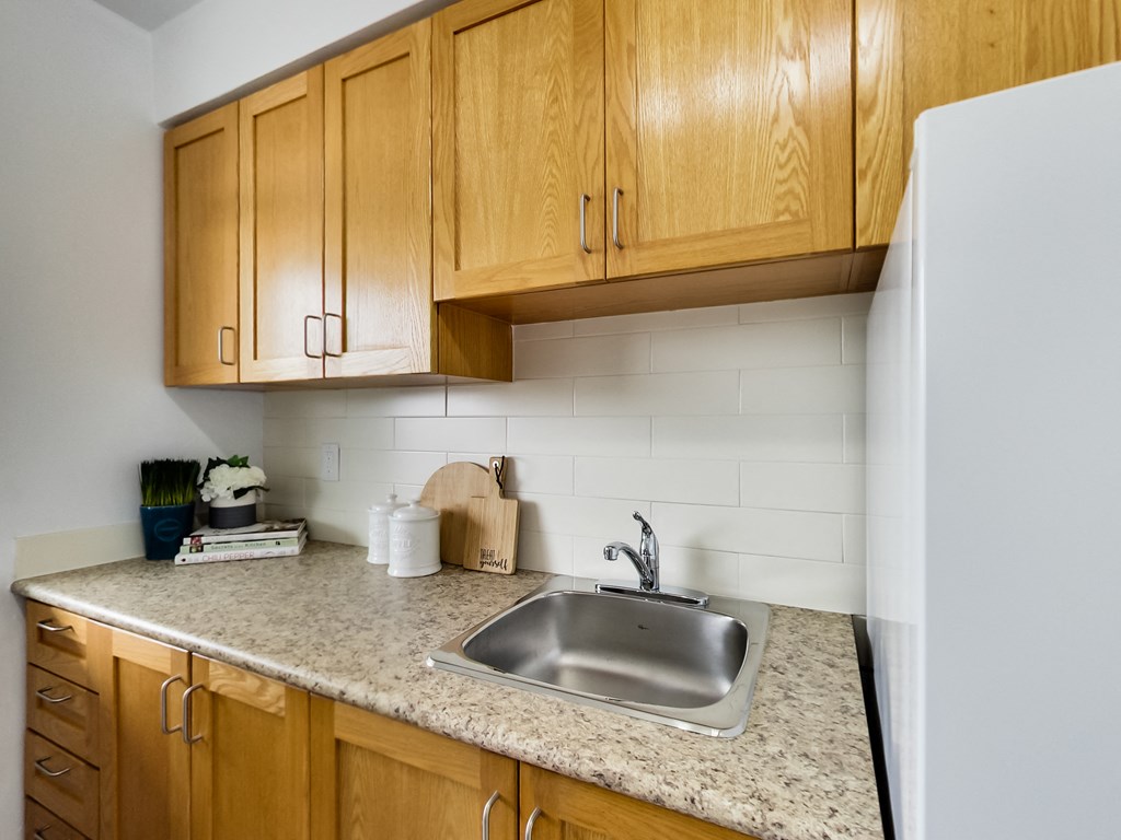 A kitchen with wooden cabinets and a granite countertop.
