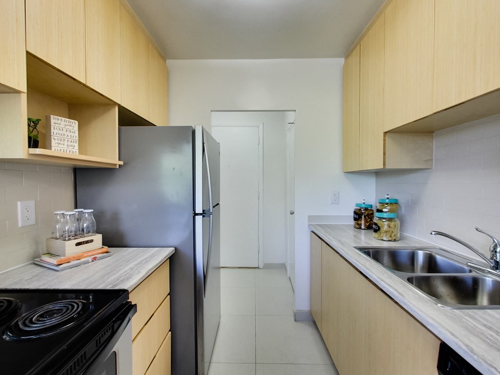 a kitchen with wooden cabinets and a stainless steel refrigerator