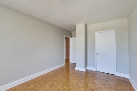 an empty living room with wood flooring and white walls