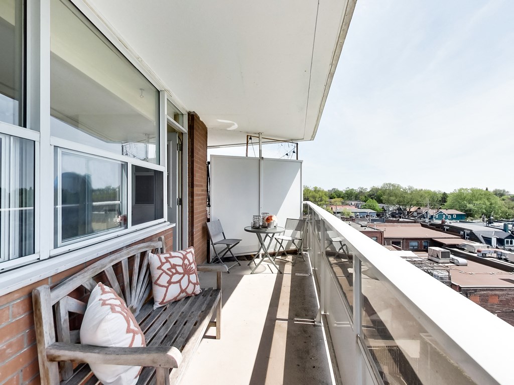 A balcony with a bench and a table.