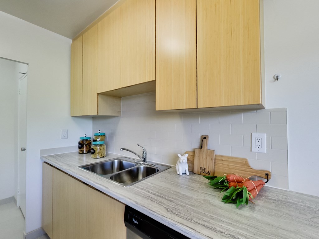 an empty kitchen with wooden cabinets and a sink
