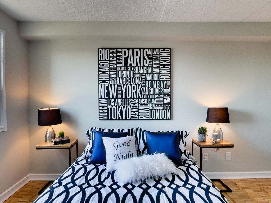 a bedroom with a bed with blue and white pillows and a sign above it
