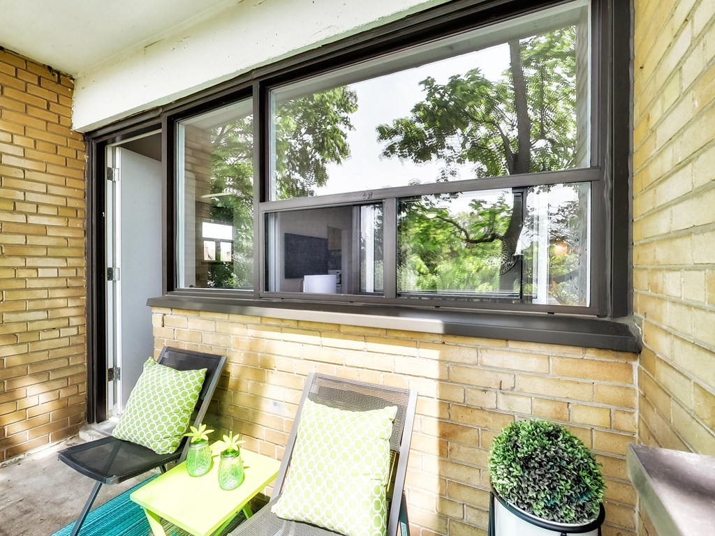 A patio with a table, chairs and a window.