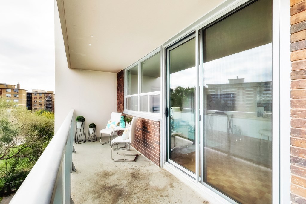 A balcony with a person sitting on a chair.