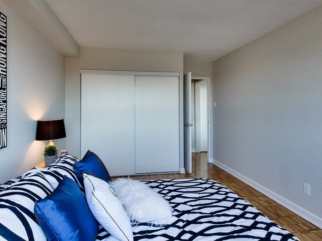 a bedroom with a bed with blue and white pillows