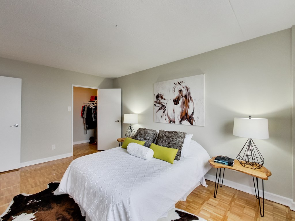 a bedroom with a white bed and a painting on the wall