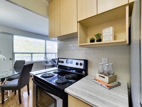 A modern kitchen with a black stove top oven and a marble countertop.