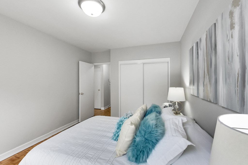 a bedroom with a large white bed with blue pillows