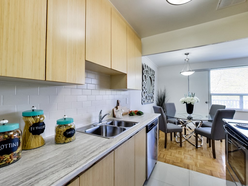 an open kitchen and dining room with a table and chairs and a sink