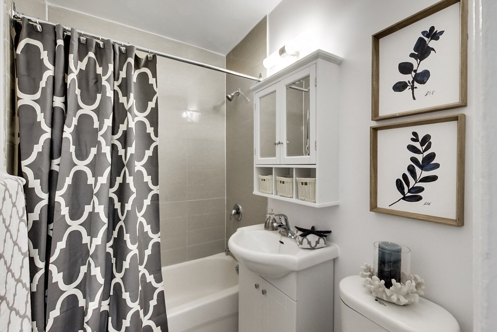 a white bathroom with a black and white shower curtain