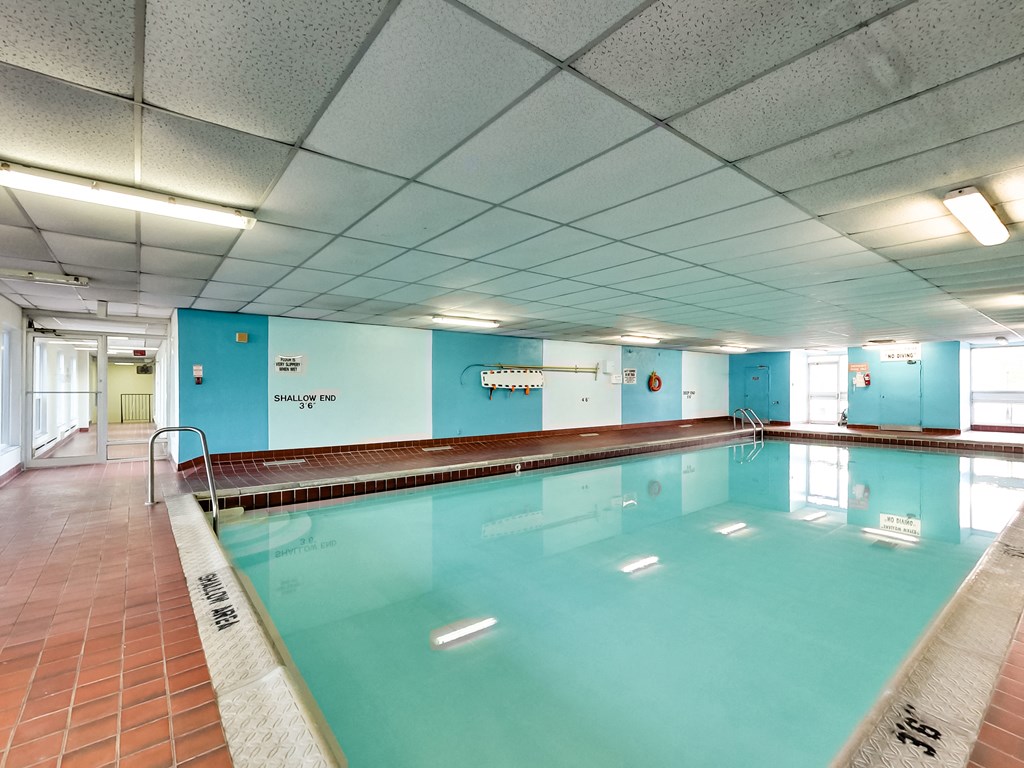 a large swimming pool in a building with blue walls
