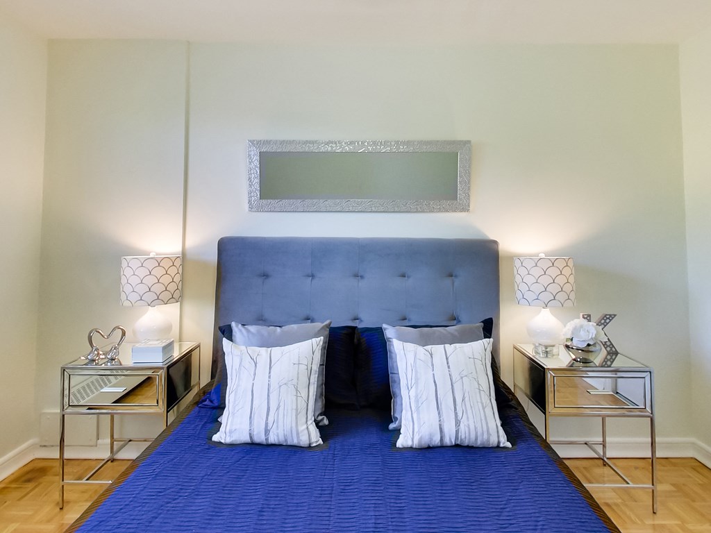 a bedroom with a blue bed and a blue blanket and pillows