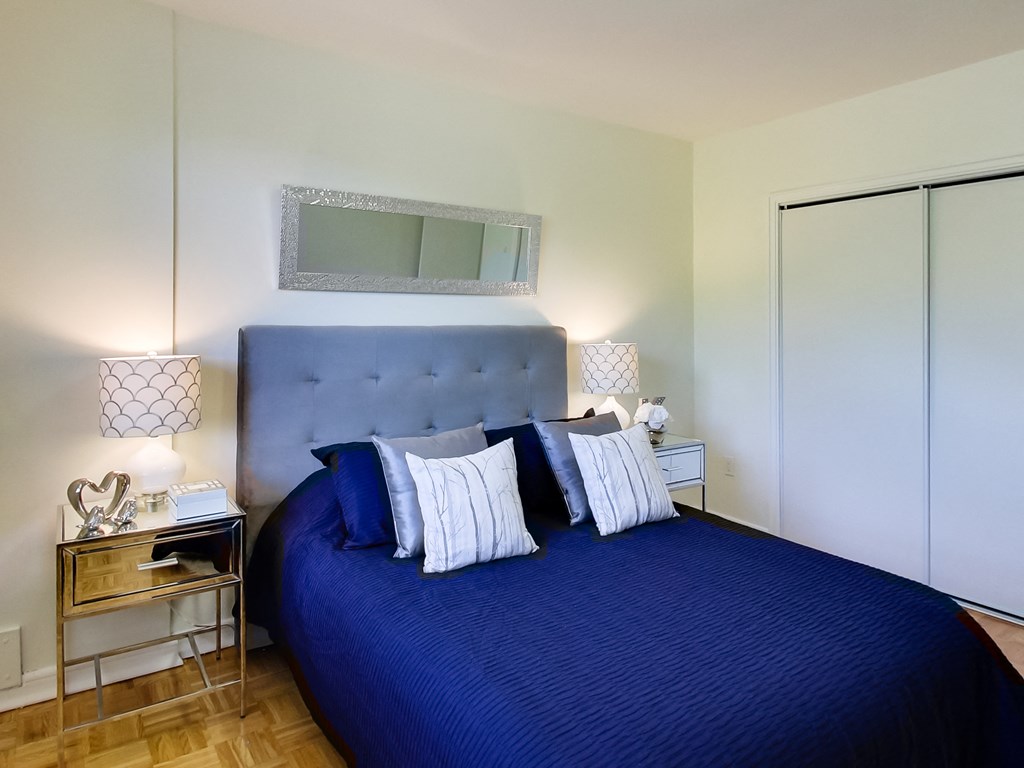 a bedroom with a blue bed and white walls