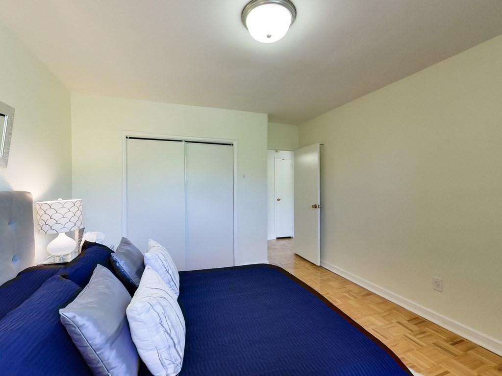 a bedroom with a large blue bed and a closet