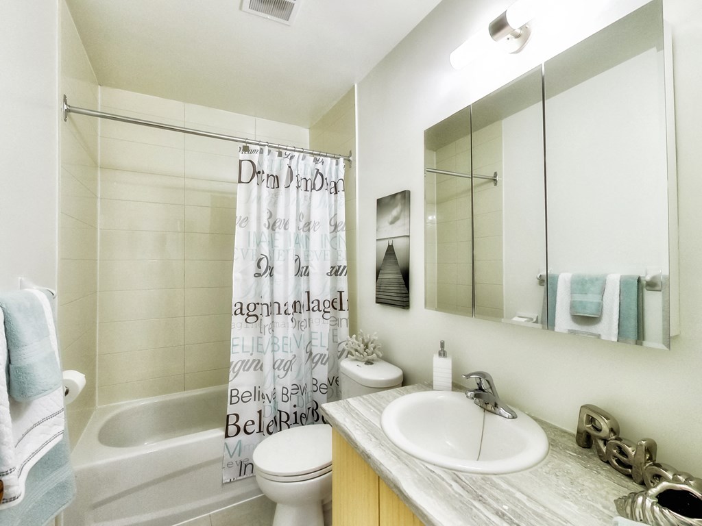a bathroom with a shower curtain and a sink and a toilet