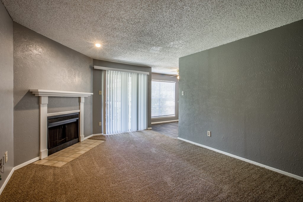 A room with a fireplace and carpeted floor.