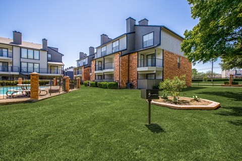 A grassy area in front of a building with a mailbox.