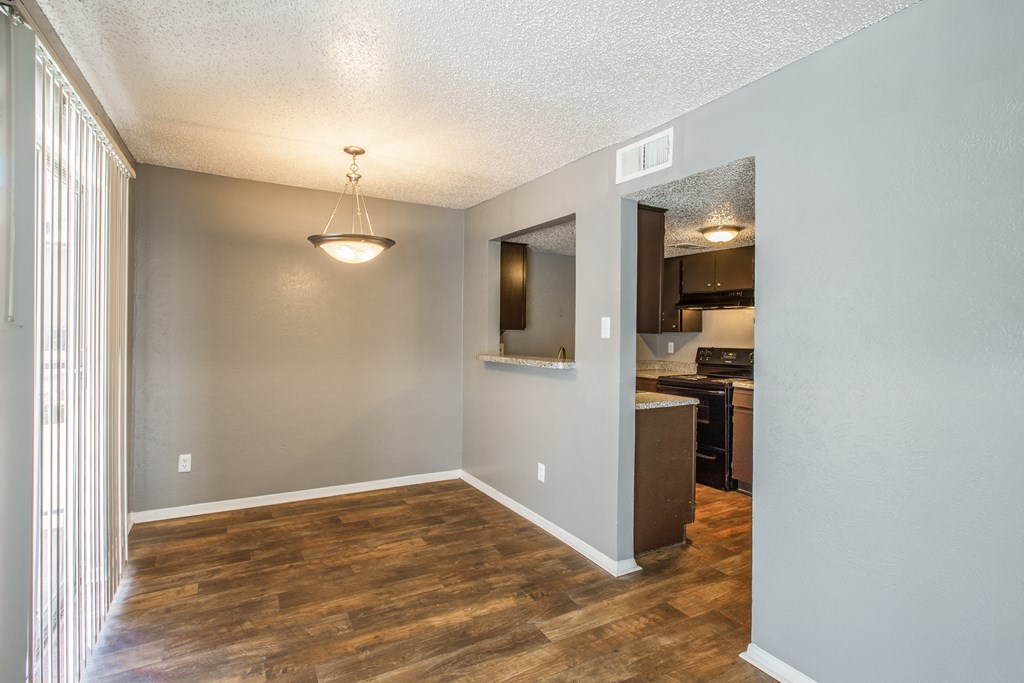 A room with wooden floors and a light hanging from the ceiling.