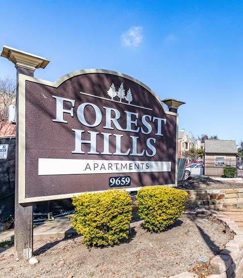 A sign for Forest Hills Apartments with the number 9659 on it.