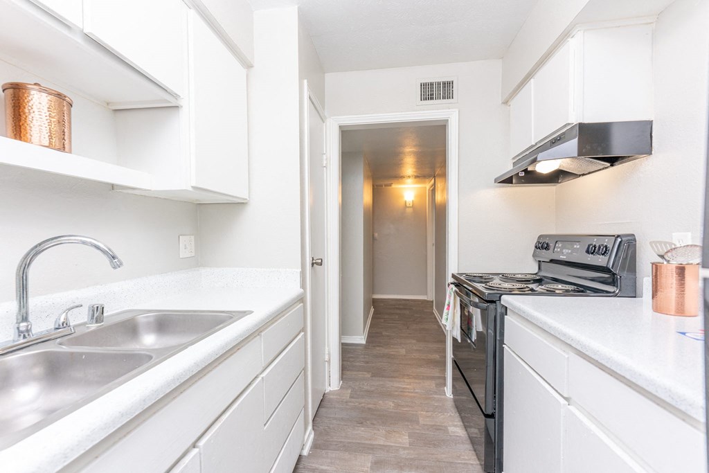 a renovated kitchen with white cabinets and a stainless steel sink