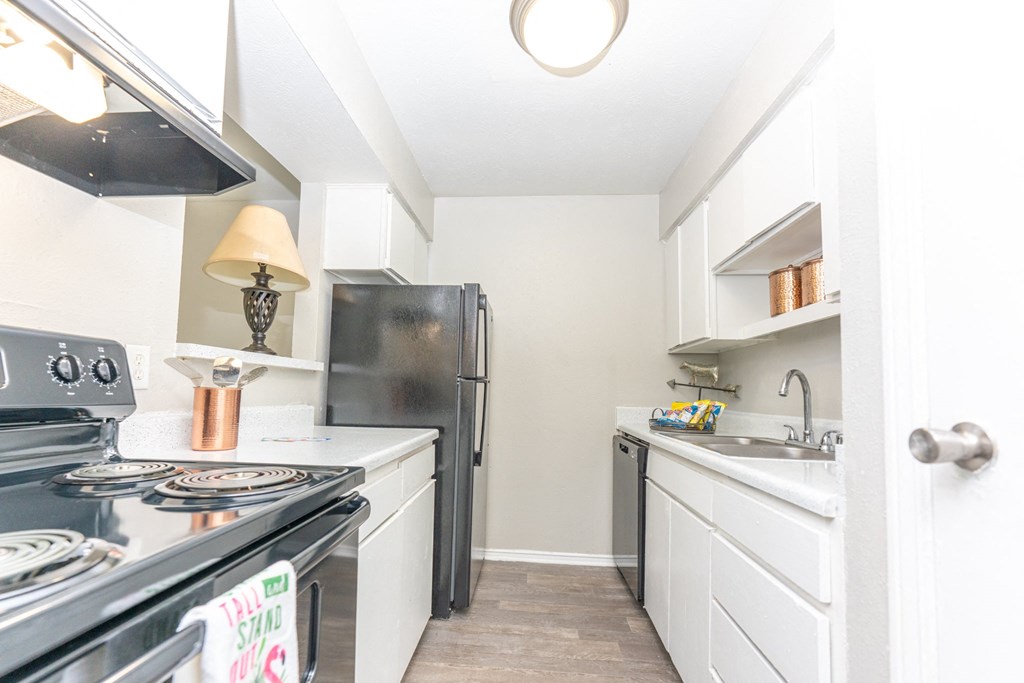 a white kitchen with stainless steel appliances and white cabinets