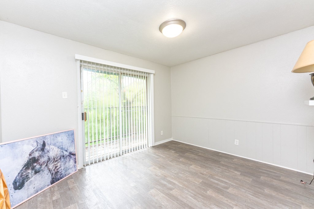 an empty living room with a sliding glass door to a patio