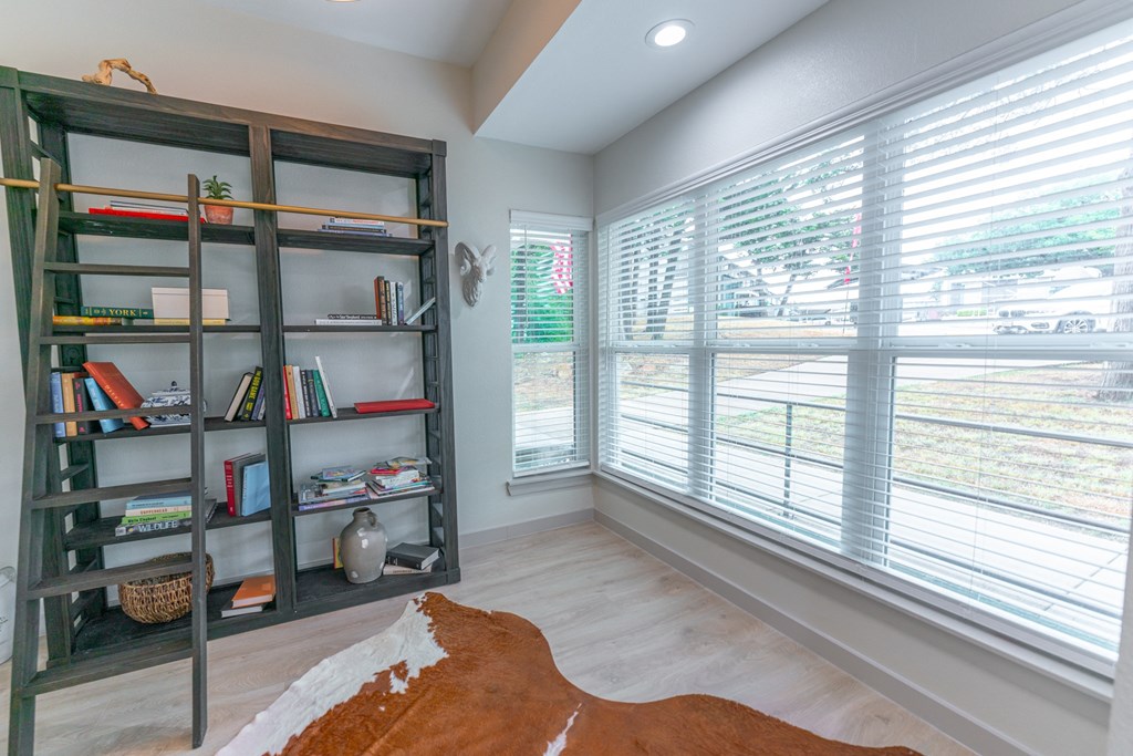 a living room with a large window and a book shelf