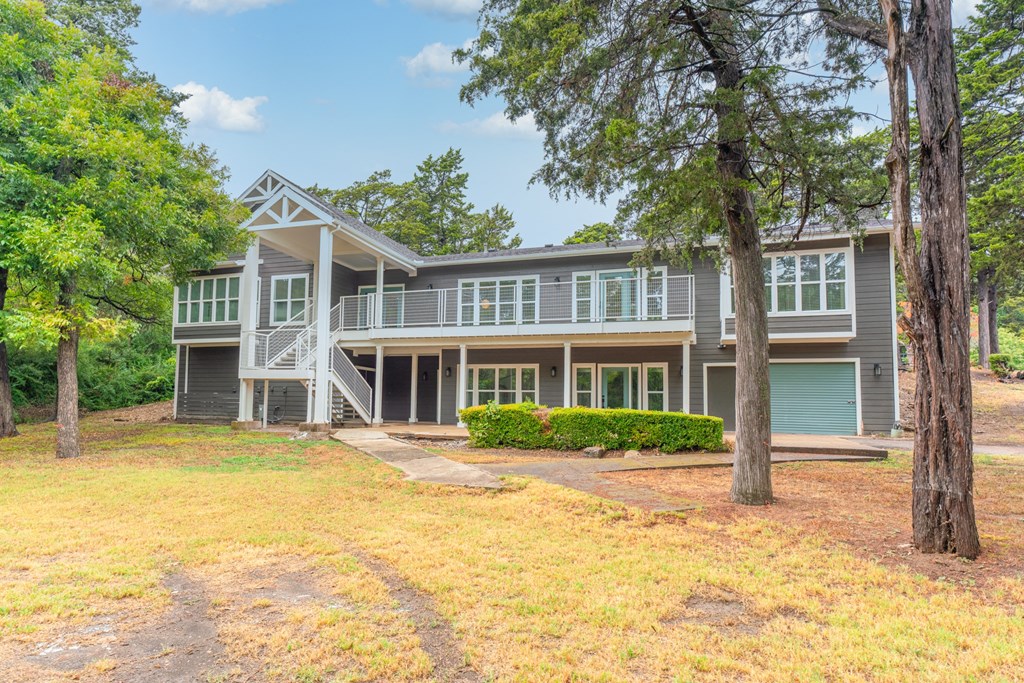 a house with a lawn and trees in front of it