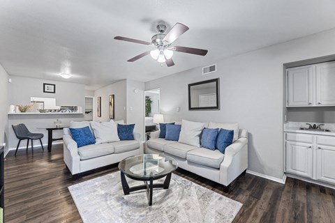 a living room with couches and a table and a ceiling fan