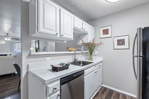 a kitchen with white cabinets and a stainless steel refrigerator