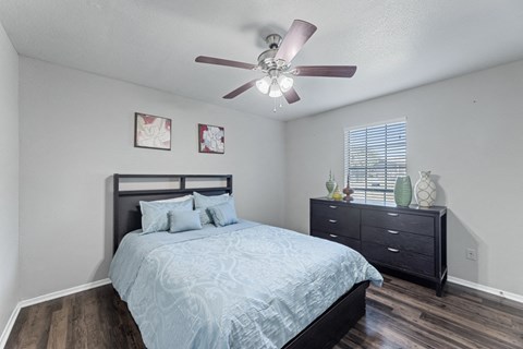 the master bedroom has a large bed and a ceiling fan