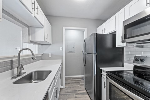 a kitchen with stainless steel appliances and white cabinets