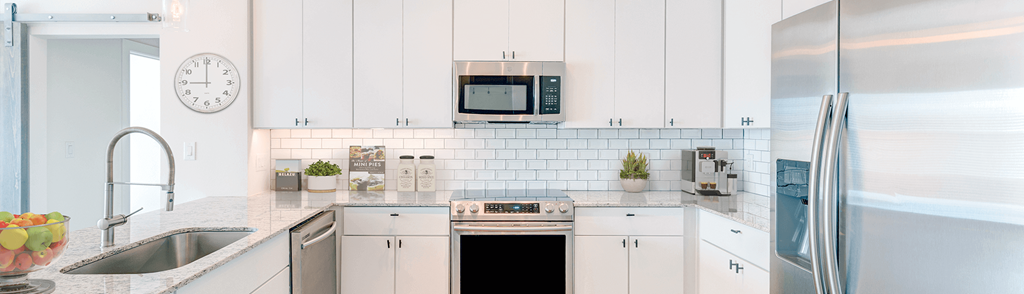 a kitchen with white cabinets and a sink and a refrigerator