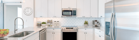 a kitchen with white cabinets and a sink and a refrigerator