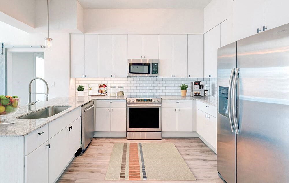a kitchen with white cabinets and stainless steel appliances