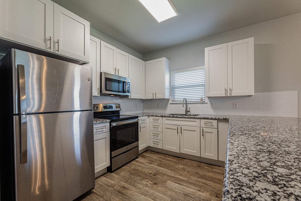 a kitchen with stainless steel appliances and white cabinets