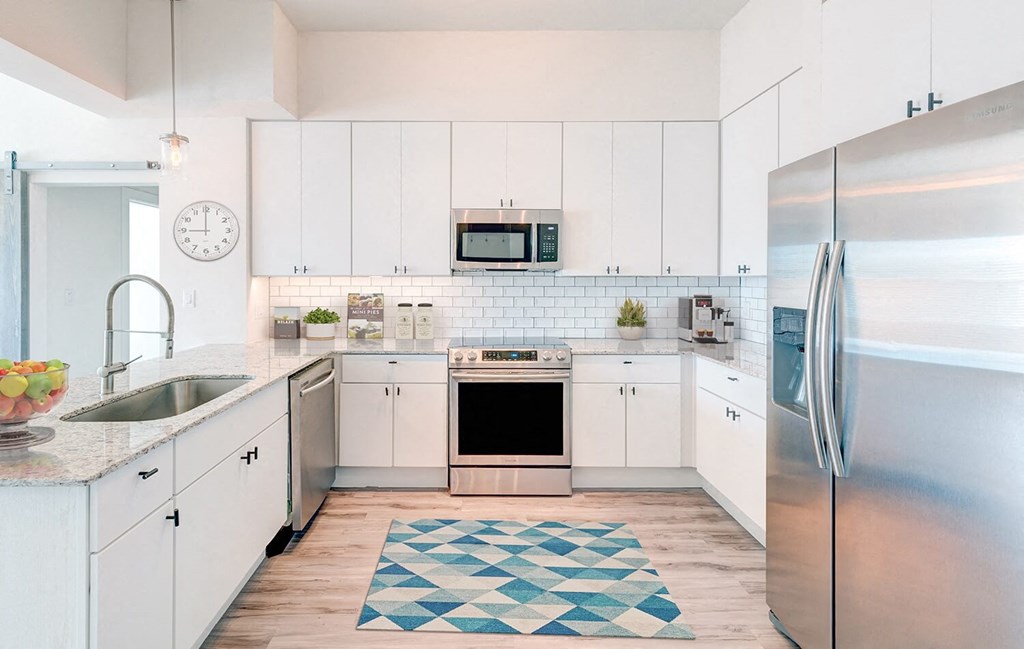 a kitchen with white cabinets and stainless steel appliances