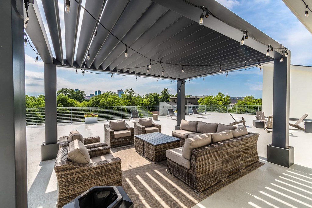 a patio with couches and chairs on a roof