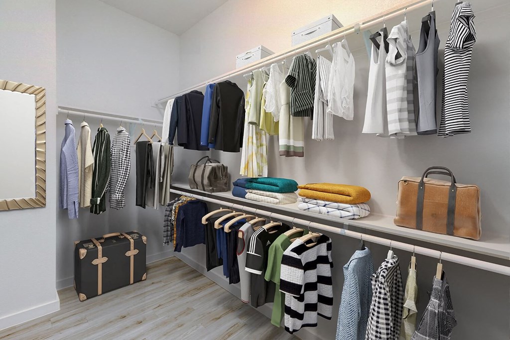 a rack of clothes and bags in a closet