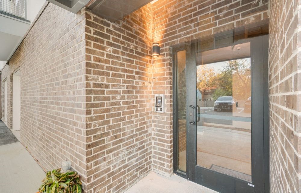 the entrance to a brick building with a glass door