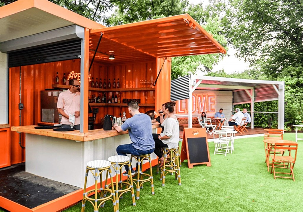 a bar with people sitting at it on the grass