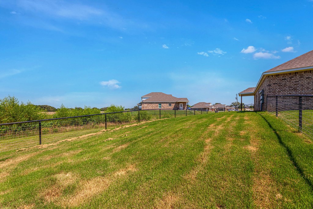 a fenced in backyard with houses in the background