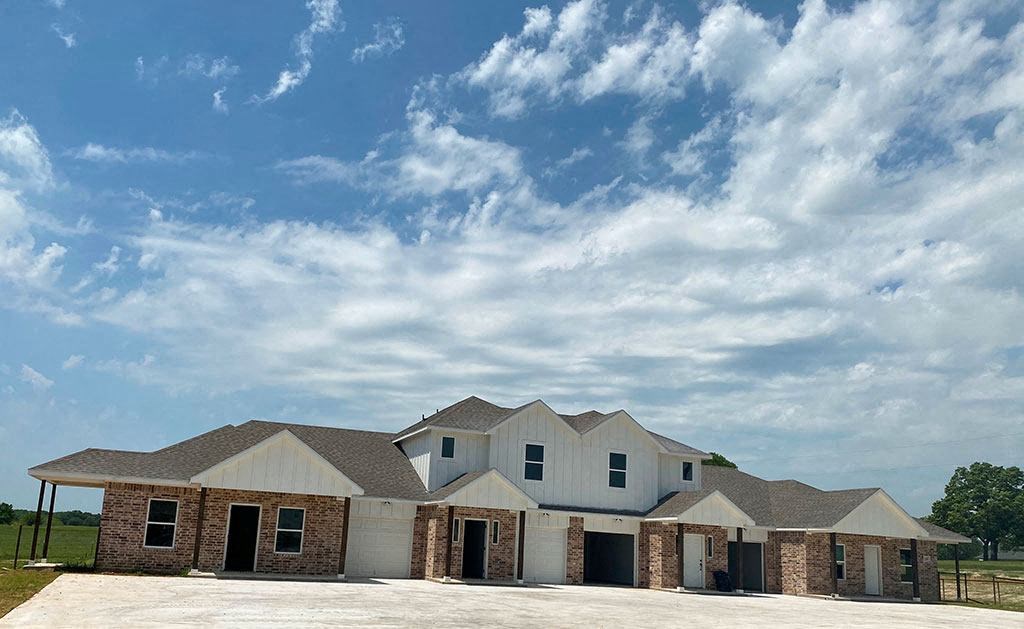 a large house with a cloudy sky above it